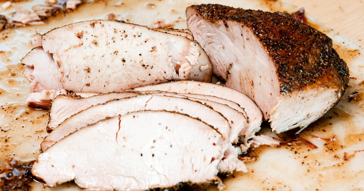 Pulled pork in a large container held by hands