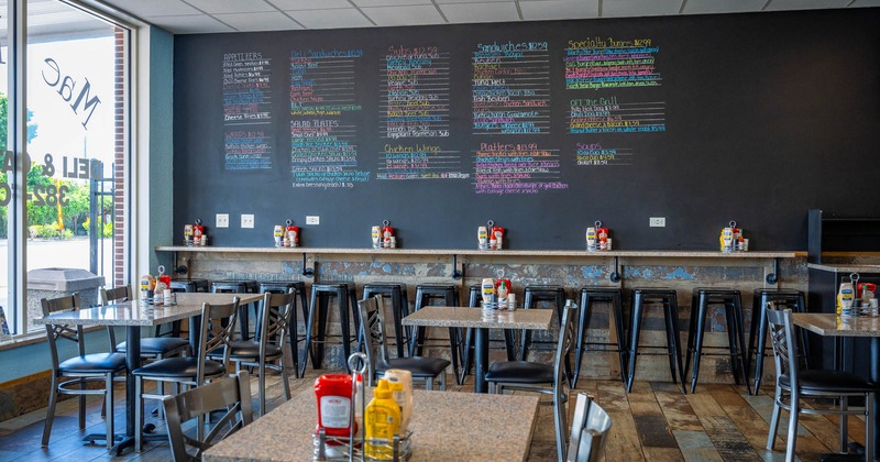 Interior, open space dining area, regular and high seating, over the wall menu board