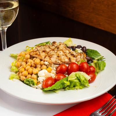 Salad with grilled chicken, lettuce, chickpeas, cherry tomatoes, olives, and feta cheese