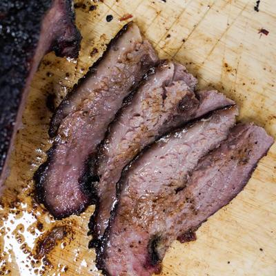 A freshly sliced smoked beef brisket on a cutting board.