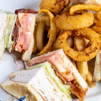 Club Sandwich with onion rings on the side.