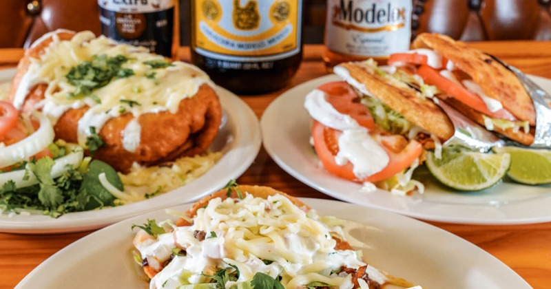 Mexican dishes and beers on a table