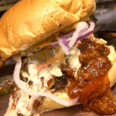 Burger with red sauce, coleslaw, and onion.