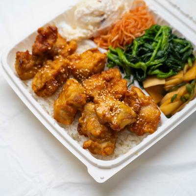 Mochiko chicken, rice, potato salad, marinated carrots, greens, and pickled vegetables.