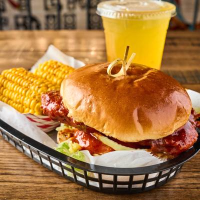 Peri Grilled Chicken Burger served with corn on the cob.