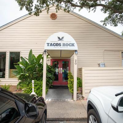 Exterior with signage and two parked cars.