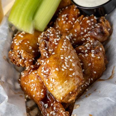 Jumbo wings with sesame served with celery and dressing.