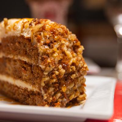 Close-up of a carrot cake slice on a white plate.