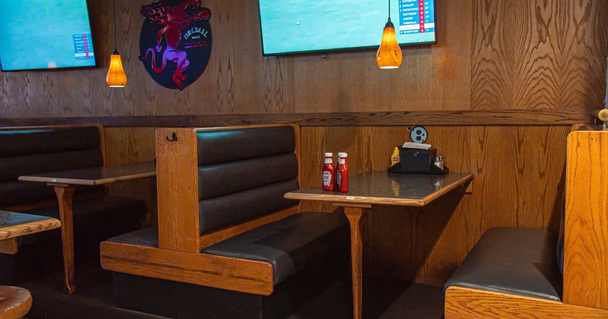 Interior - wooden booths, two TVs showing sports and a decorative 