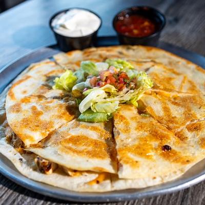 Chicken quesadilla with condiments.