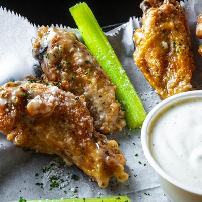 Garlic Parmesan Chicken Wings served with celery and ranch sauce.