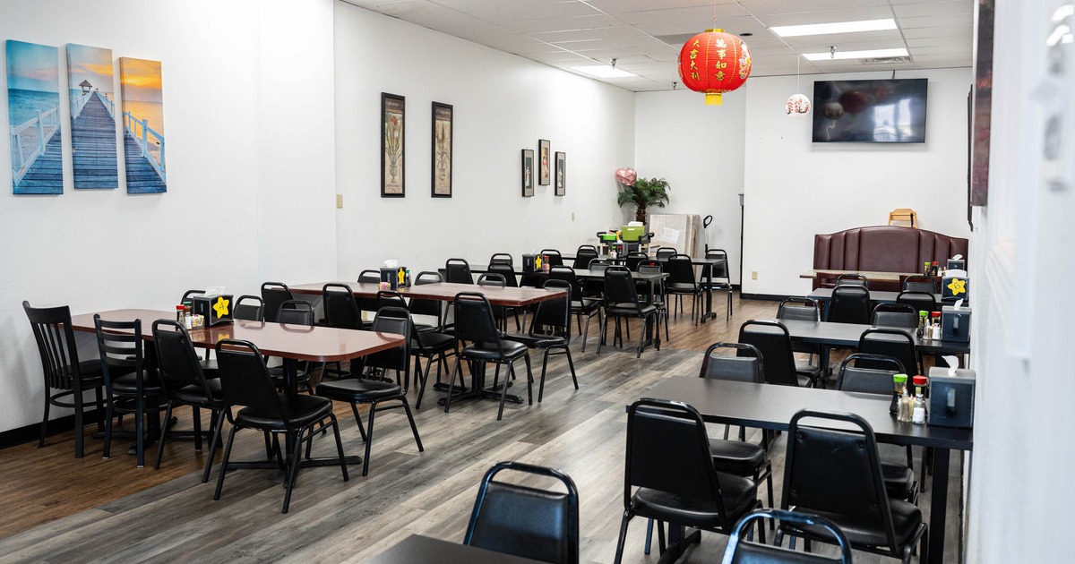 Interior with laminate wood flooring, black metal chairs, and a festive red lantern