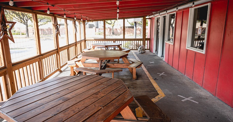 Exterior, covered seating area, octagonal wooden tables with benches around it