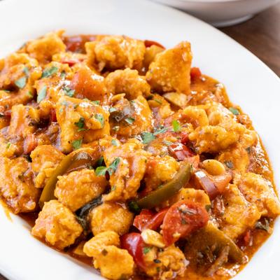 Chicken sauteed in spicy tomato sauce with peppers and herbs.