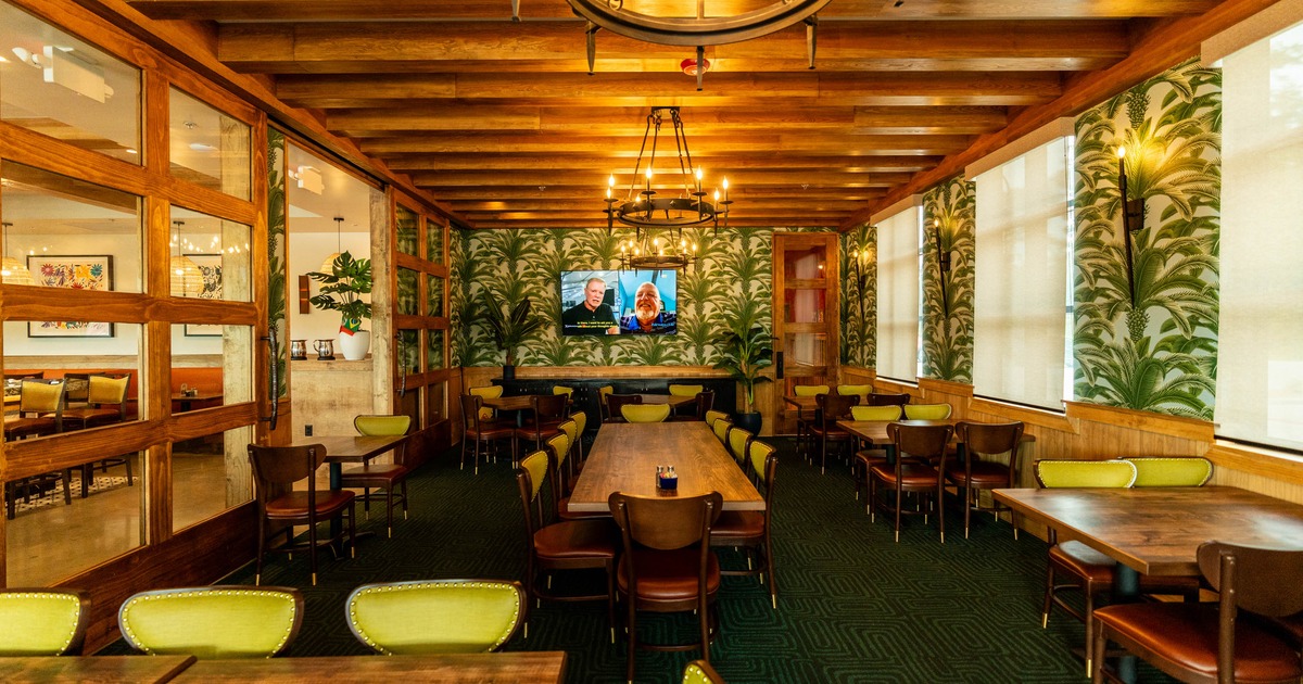 Interior seating area with wooden tables with green and brown chairs
