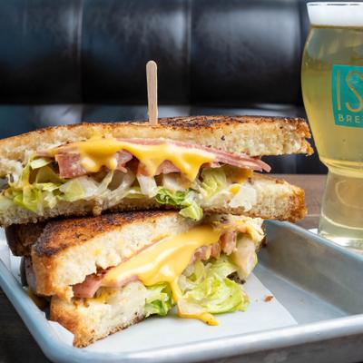 A loaded fried bologna and cheese sandwich paired with a craft beer.