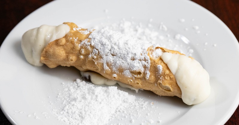 Cannoli filled with cream, topped with powdered sugar