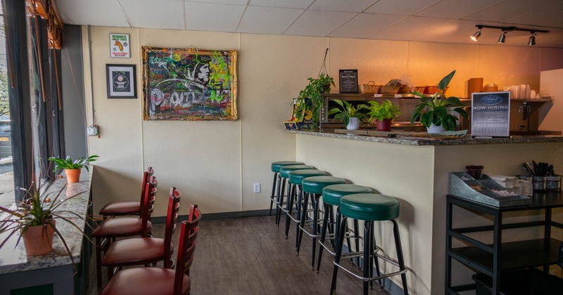 Interior, high seating area, bar with stools, large shop window, various decoration