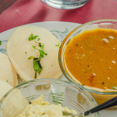 Three rice puffs served with vegetable lentil stew and coconut chutney.