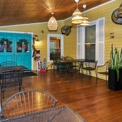 Covered porch seating with warm lighting and festive decorations.