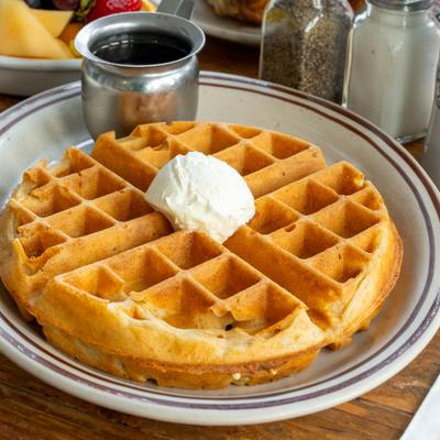 Huckleberry Waffle topped with mascarpone cheese and served with syrup.