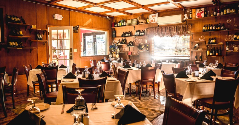 Interior, set tables, chairs, bottles on shelves, glasses, lighting, windows