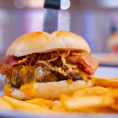A hearty burger, served alongside a pile of french fries.