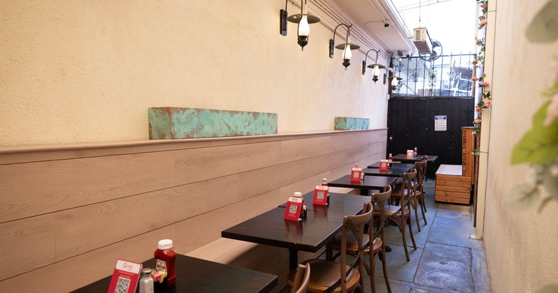 Interior, narrow dining room, banquette bench with tables and chairs, high ceiling