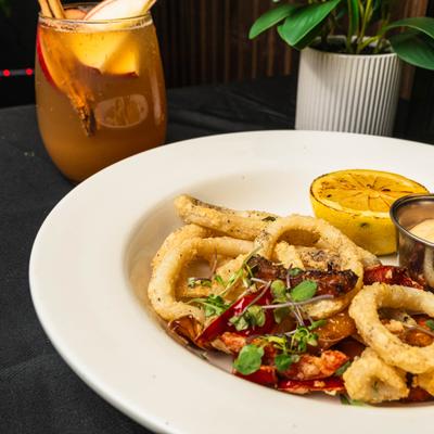 Fried calamari served on the table with a cocktail.