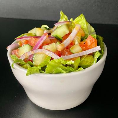 Side salad wiht lettuce, tomato, cucumber, onion, and orange vinaigrette