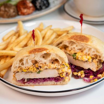 A grilled chicken sandwich on ciabatta bread served with french fries.