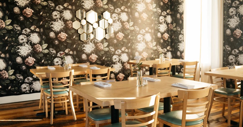 Interior, guest tables and chairs, curtains with floral print
