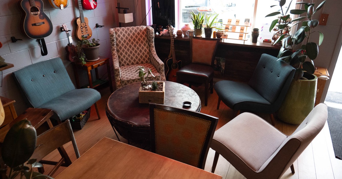 Interior, lounging area, armchairs around the coffee table, guitars hanging on the wall