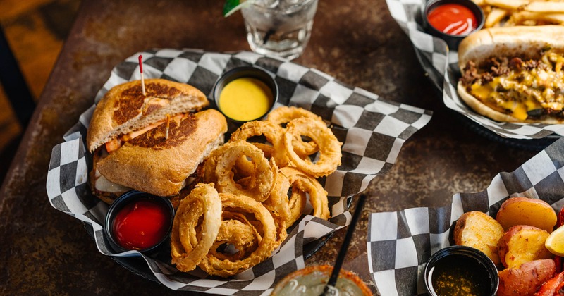 Honey Mustard Chicken sandwich with onion rings, alongside other dishes and drinks
