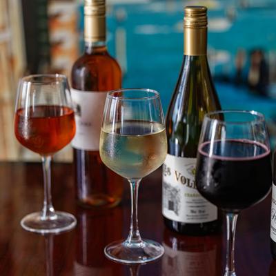 Wines in glasses with bottles in the back