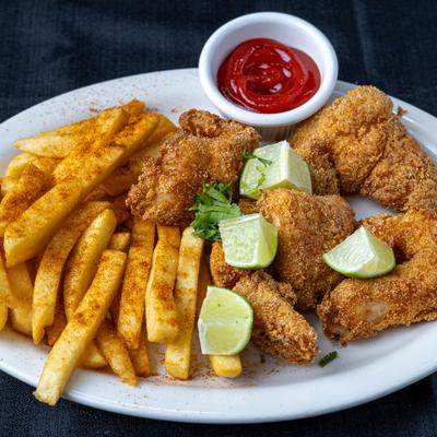 Fried catfish with fries, ketchup, and lime wedges.
