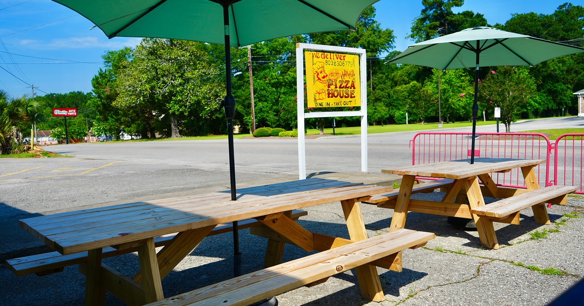 Outdoor seating area, a conjoined tables and benches, and parasols