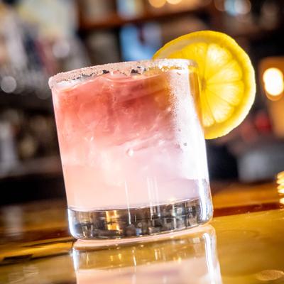 Blackberry margarita with a lemon wheel.