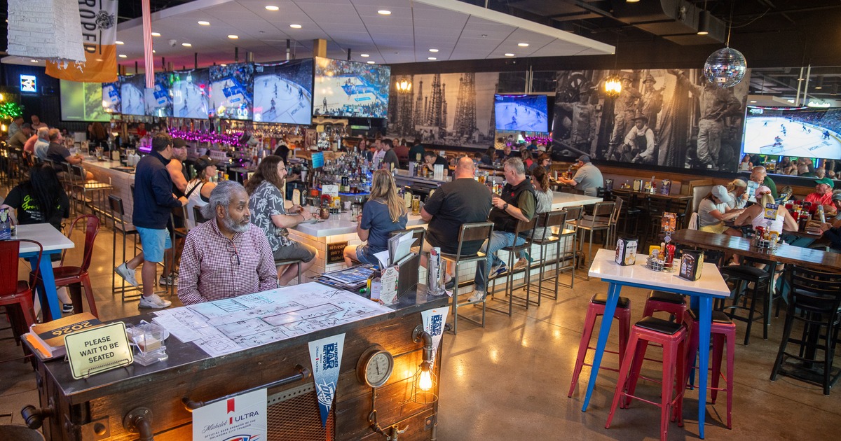 Interior, bar area, people, bar, bartender, screens above