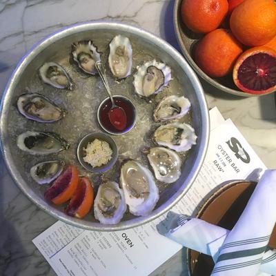 fresh oysters arranged in a circle on ice