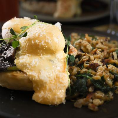 A close-up of eggs Benedict with mushrooms.