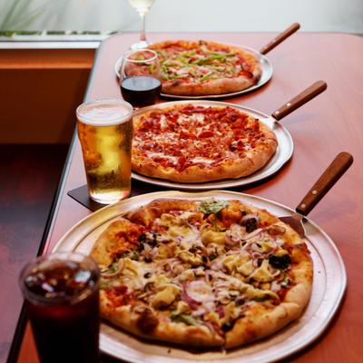 Assorted pizzas and drinks.