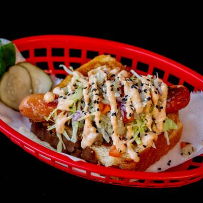 A red basket holds Big Mac Dog on a dark background.