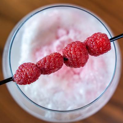 Raspberry Bellini, garnished with raspberry skewer