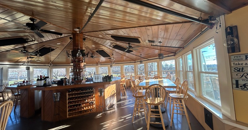 Sunlit dining area with a bar and large windows