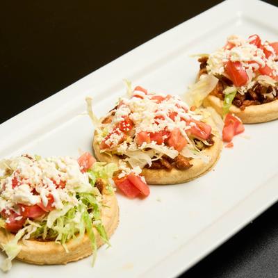 Fried masa dough, with grilled meats, lettuce, tomato, and cheese.