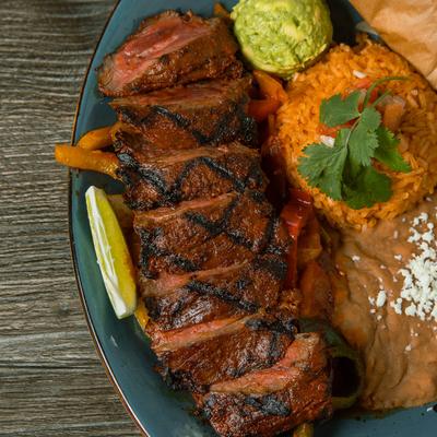 Marinated skirt steak, with guacamole, rice, and beans.