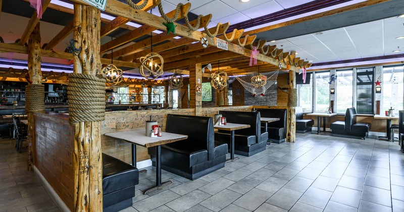 Interior - wooden beams, leather booths, round light fixtures, large windows.