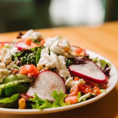 House salad with radishes and crumbled cheese, close up view.