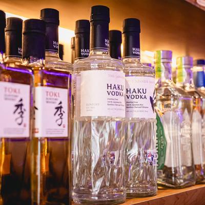 Japanese hard liquor bottles on a bar shelf, close up.